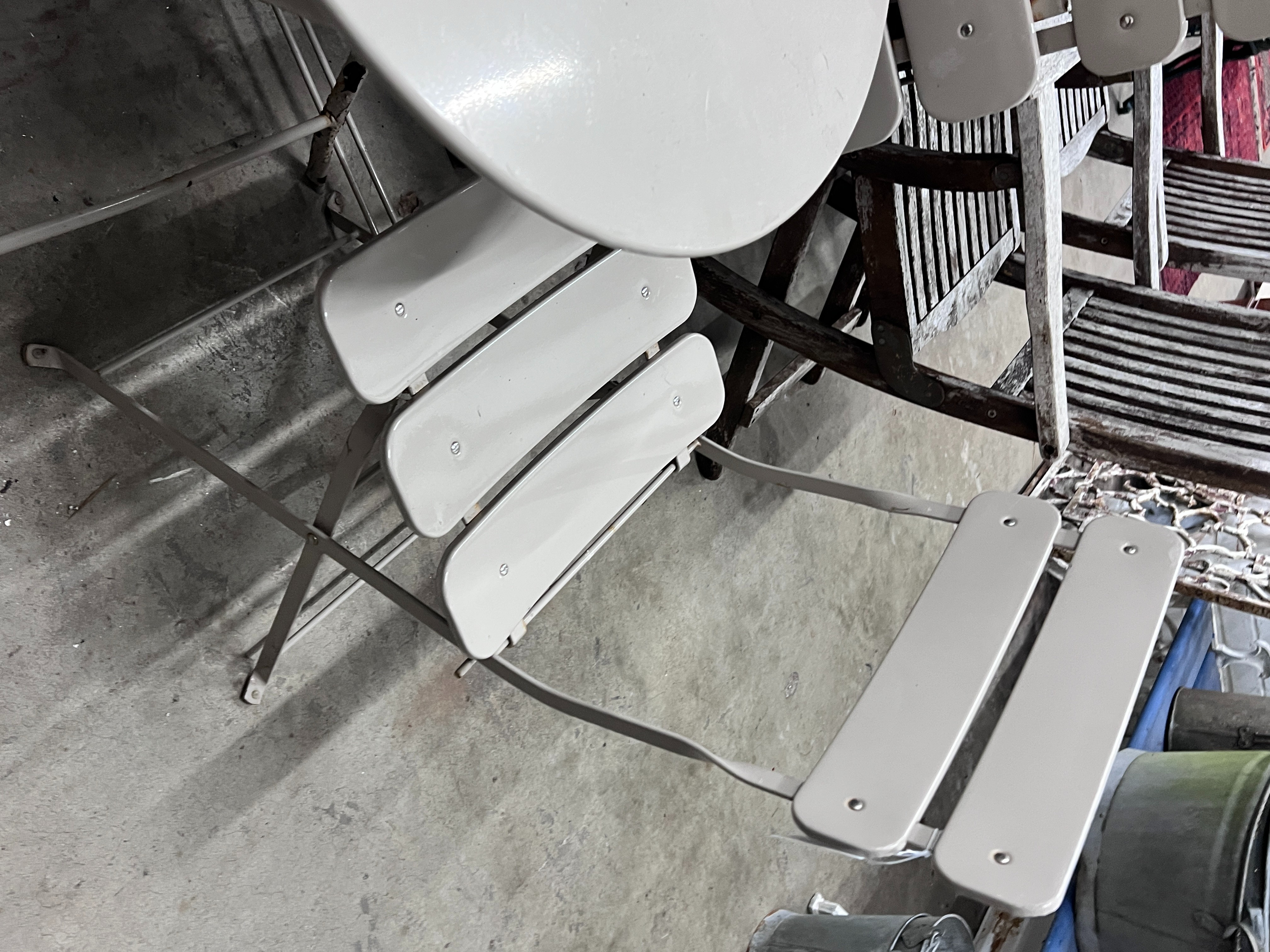 A circular painted metal folding garden table, diameter 60cm, height 71cm and two folding chairs